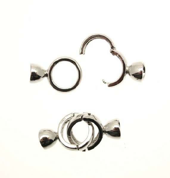 Chiusura a tondo con agganci a finalino con possibilità di incollo o di fermare i fili, 34x14 mm.
