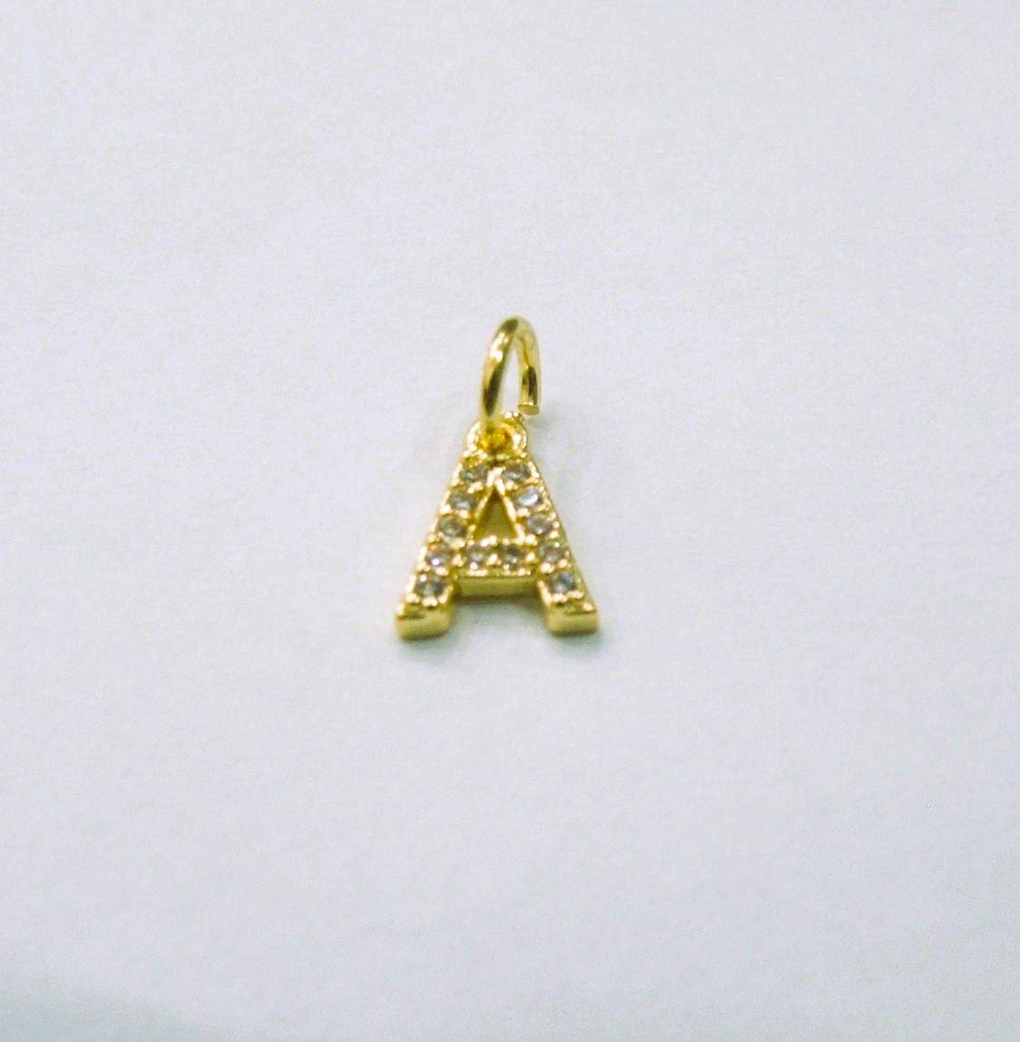 Ciondolo a forma di lettera "A", 9x7 mm., strass colore Crsytal, base colore Oro Lucido